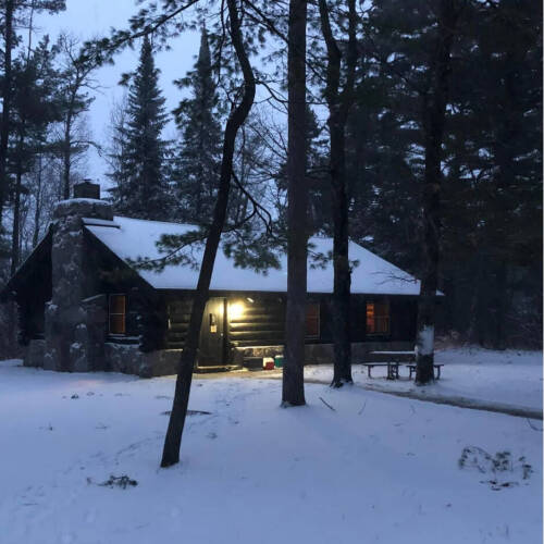 A cabin in the woods with snow on the ground